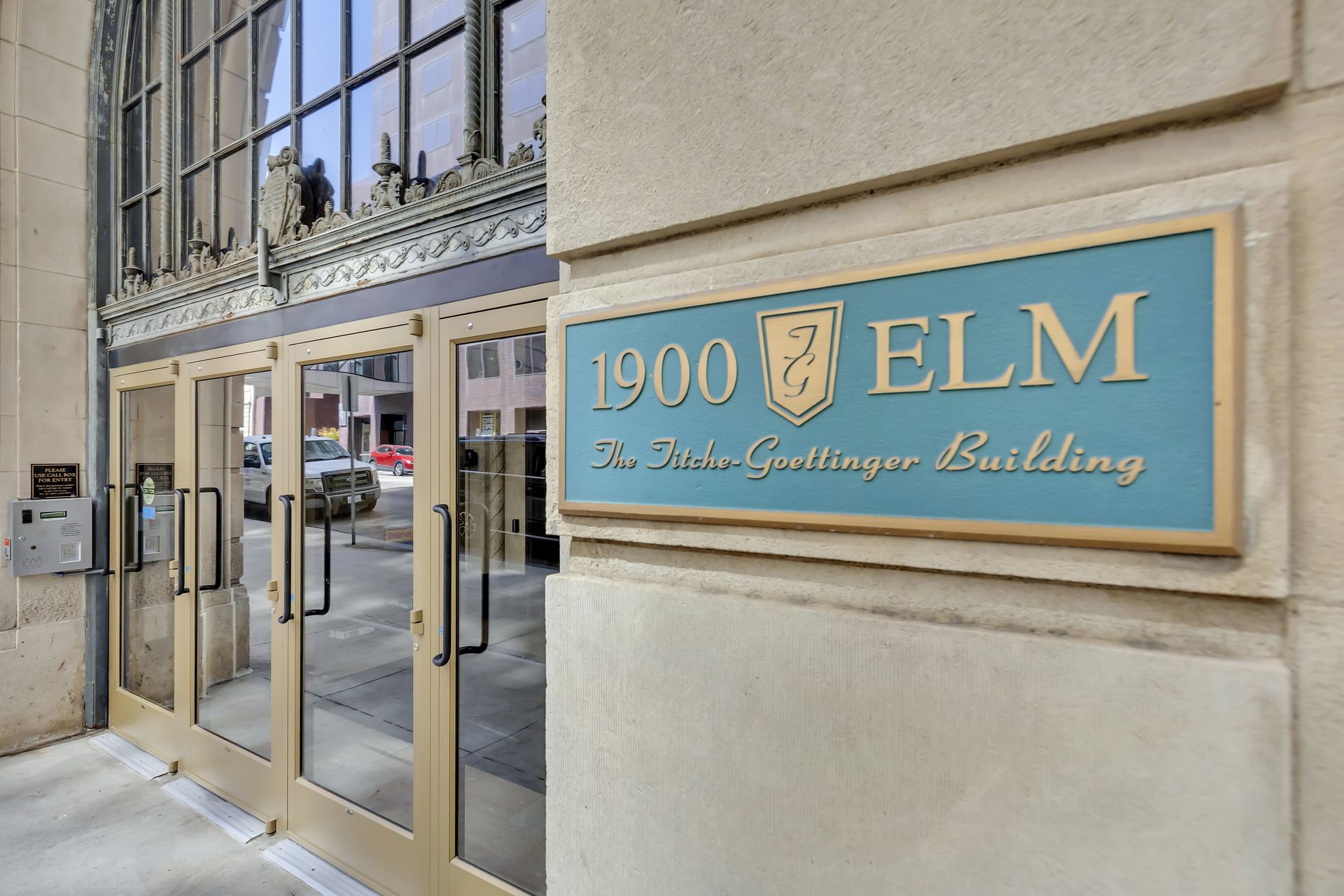 Bronze plaque reading 1900 Elm, The Titche-Goettinger Building, beside the entrance