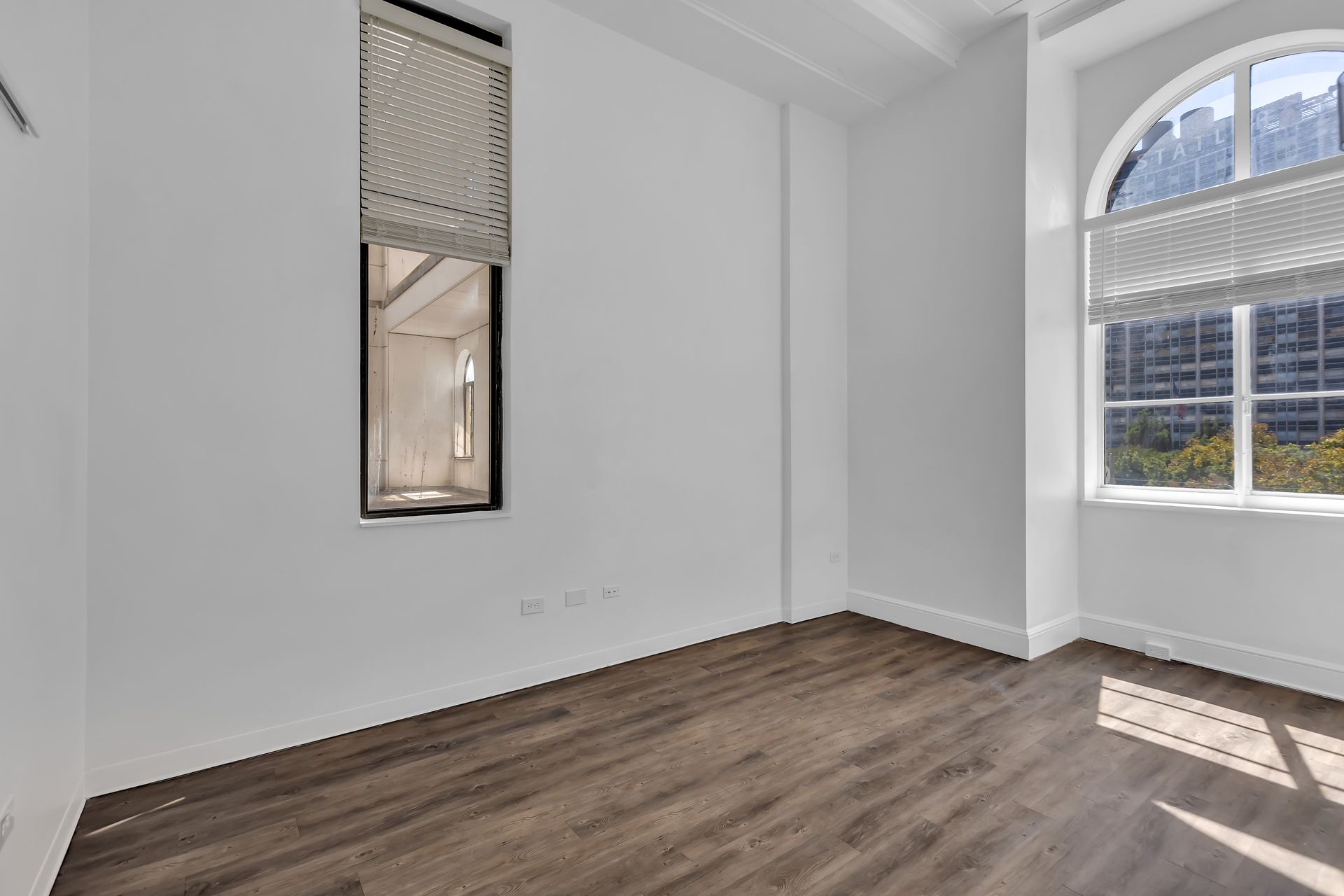 Bedroom with a tall window in a Two-Bedroom Loft, 1900 Elm Lofts