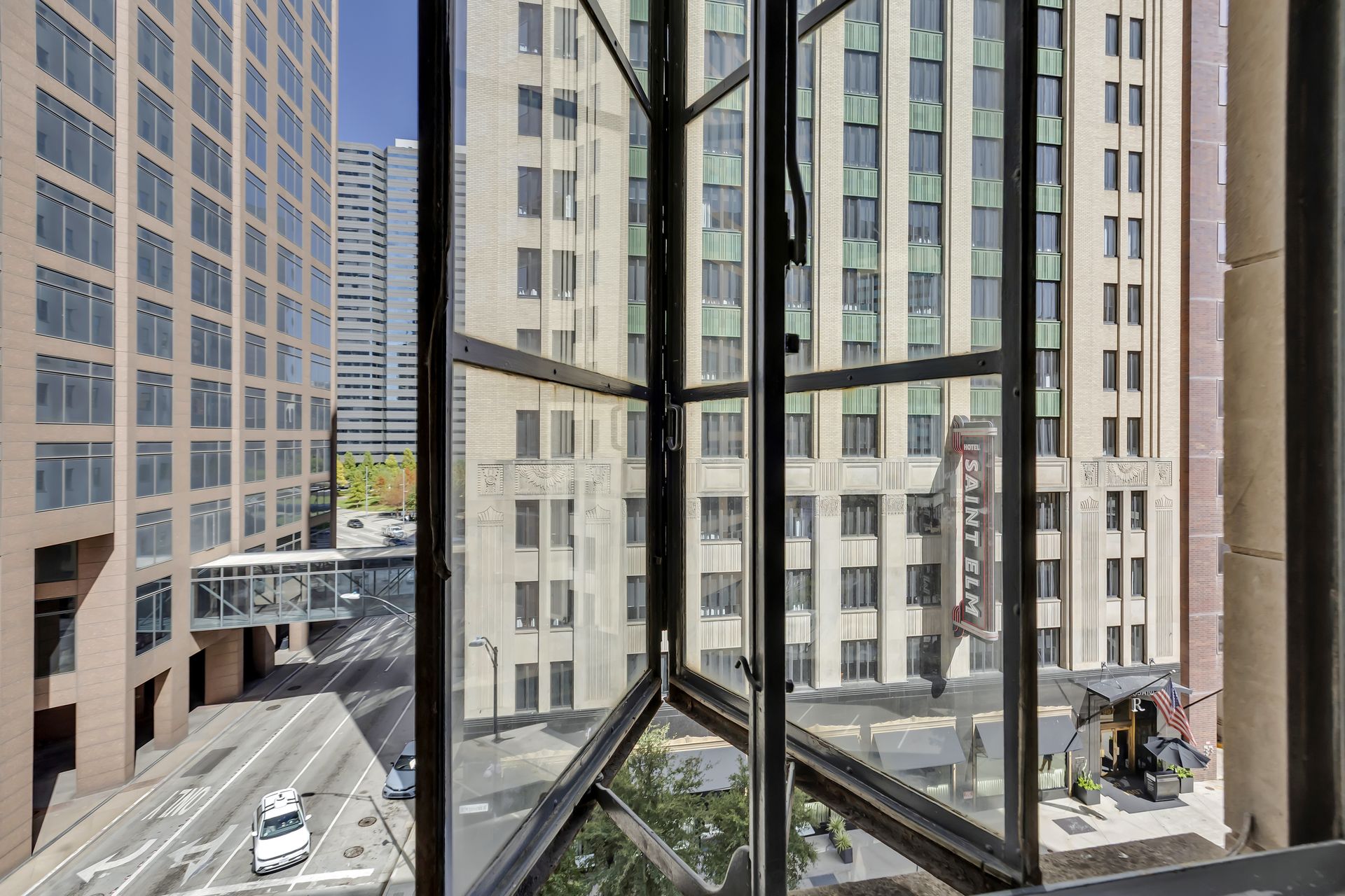 Open casement window with a view of downtown Dallas towers from a Grand Loft at 1900 Elm